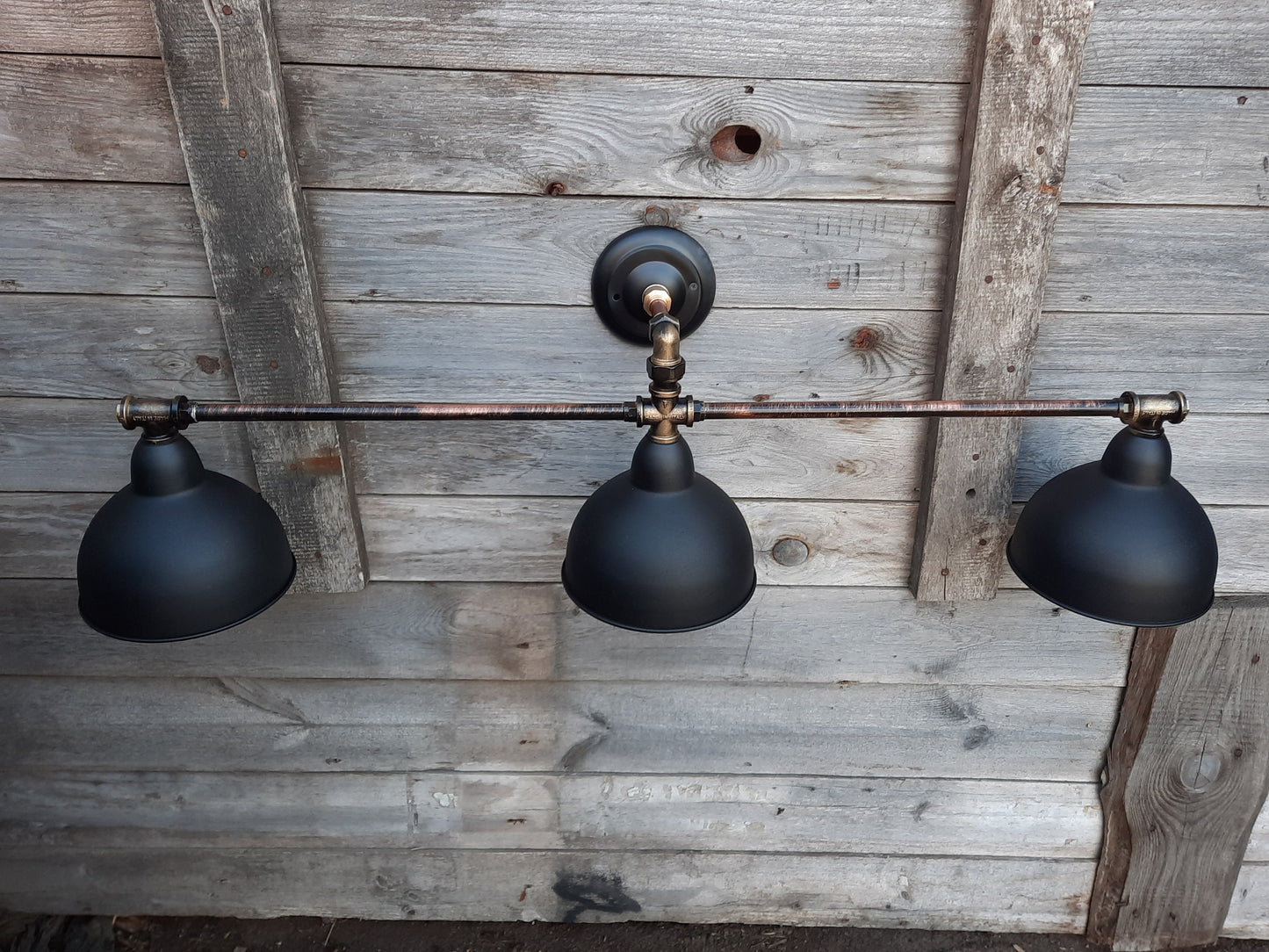 Long black wall sconce in industrial style. Rustic wall lamp for the bathroom.