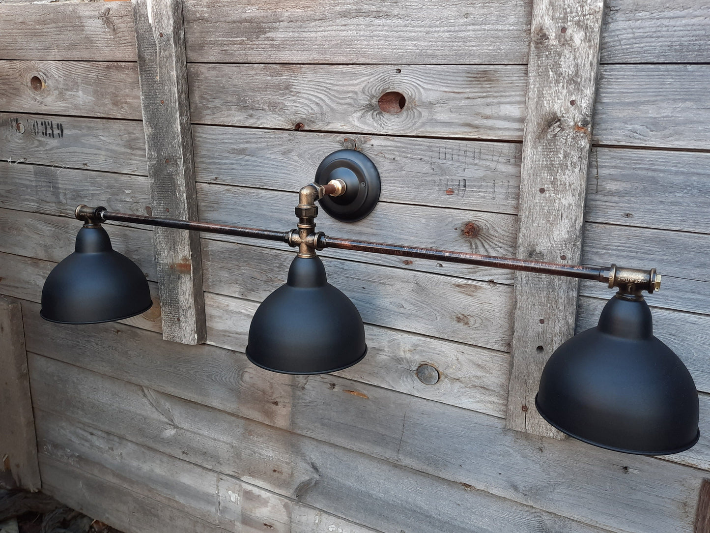 Long black wall sconce in industrial style. Rustic wall lamp for the bathroom.