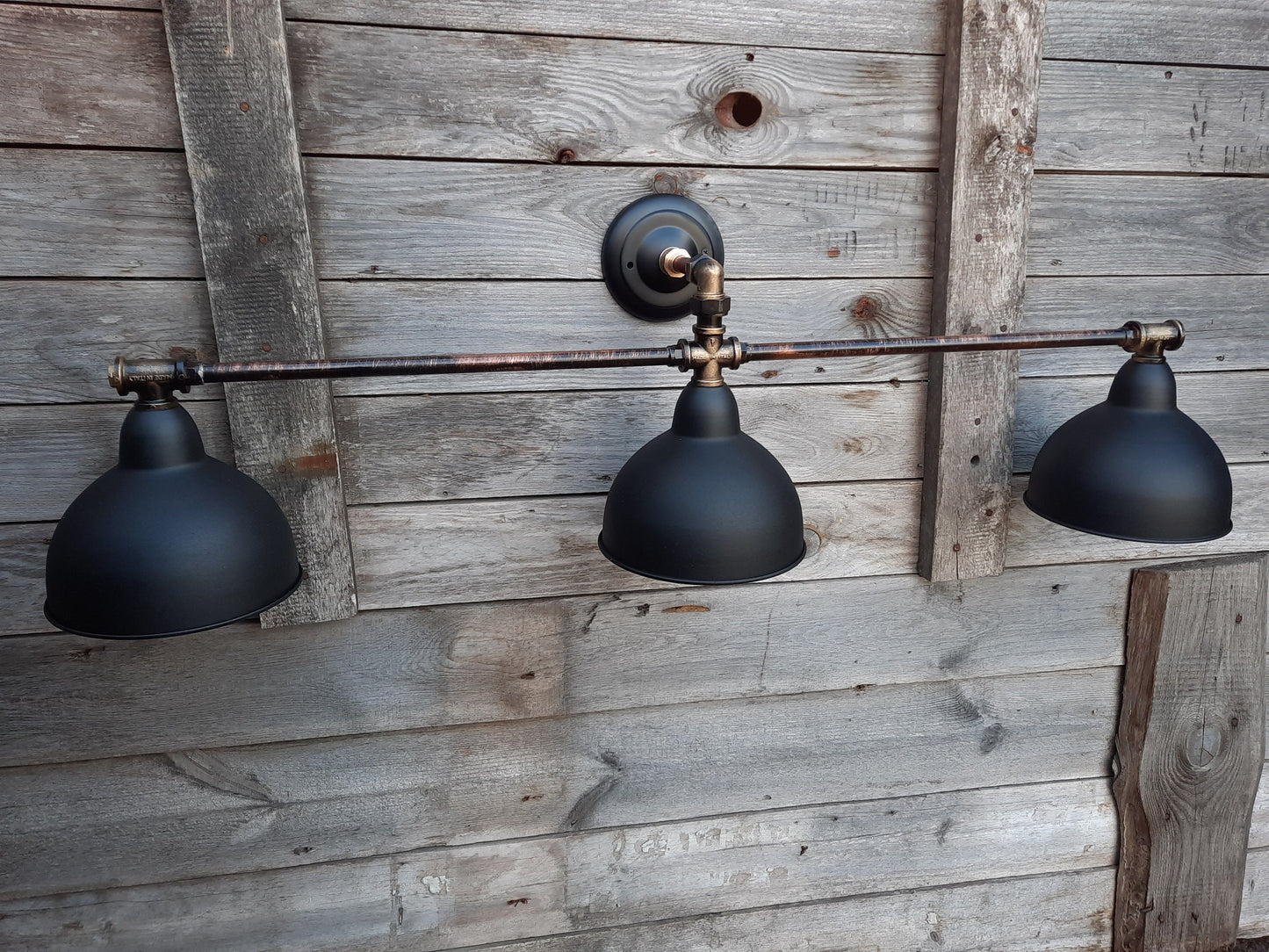 Long black wall sconce in industrial style. Rustic wall lamp for the bathroom.